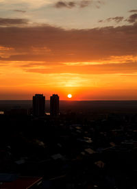 Silhouette buildings against sky during sunset