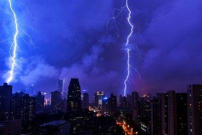 Lightning in sky above city at night