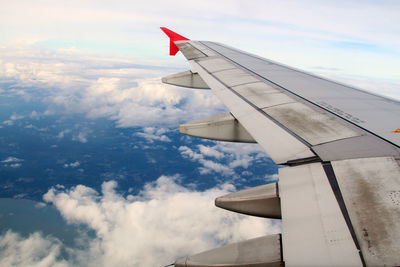 Airplane flying over clouds against sky