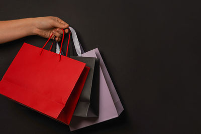 Cropped hand of woman holding box against black background