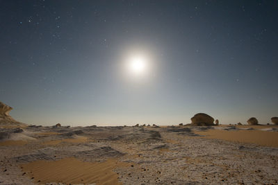 Scenic view of desert against clear sky at night