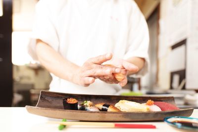 Midsection of man preparing food in kitchen