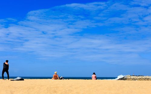 People at beach against sky