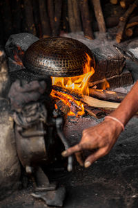 Close-up of hands holding burning candles on wood