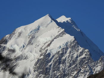 Scenic view of snowcapped mountains against clear blue sky