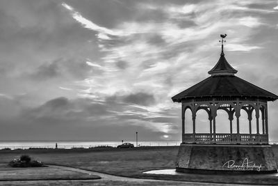 Traditional building by sea against sky