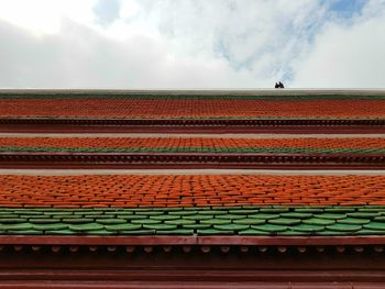 Low angle view of red house roof against sky