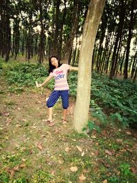 Man running on tree trunk in forest