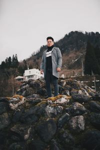 Portrait of young man standing on rock