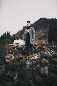 Portrait of young man standing on rock