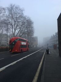 Road by buildings in city against sky
