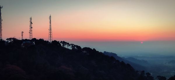 Scenic view of silhouette mountains against orange sky