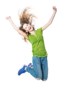 Full length of happy girl with arms raised against white background