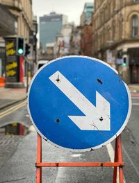 Close-up of road sign on street in city