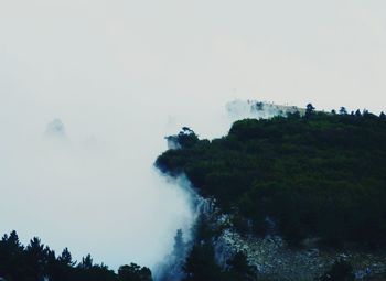 Smoke emitting from mountain against sky