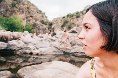 Close-up of thoughtful young woman looking away against rock formations
