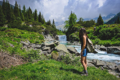 Rear view of woman hiking on mountain against sky