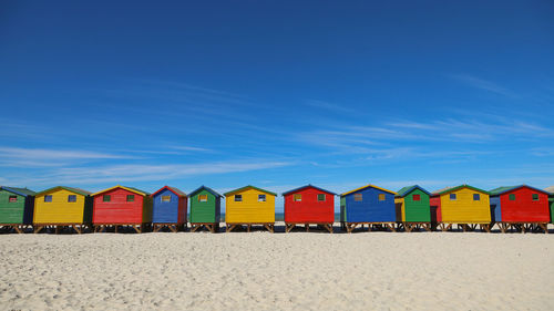 Colorful houses on beach against blue sky