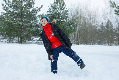A cheerful teenage boy in a winter park