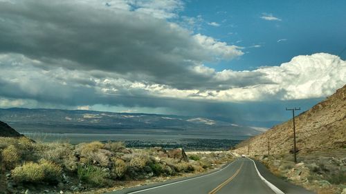 Empty road along countryside landscape