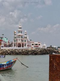 Traditional building by sea against sky