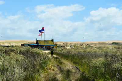 Lifeguard hut on field against sky