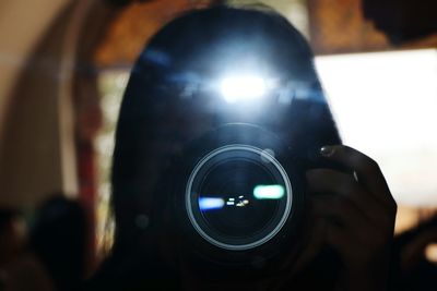 Close-up of man photographing illuminated camera