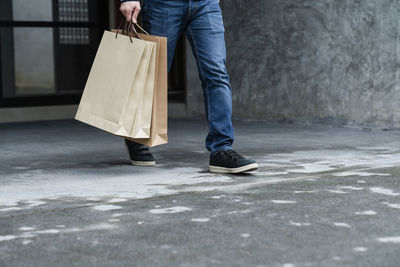 Low section of woman walking on floor in city