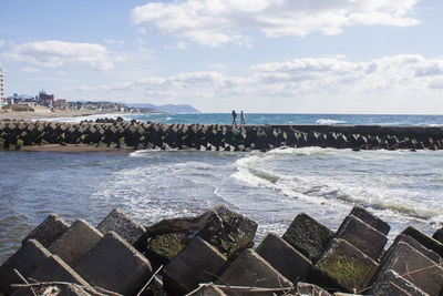 Scenic view of sea against sky, breakwater in front