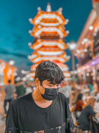 Portrait of young man standing in city