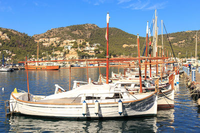 Sailboats moored on shore against sky