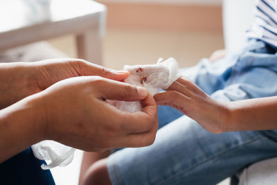 Parent helping her child perform first aid finger injury after she has been an accident.