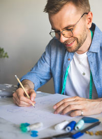 Seamster designer with glasse. diy designer draws a sketch. smiling man. real emotions, life style.