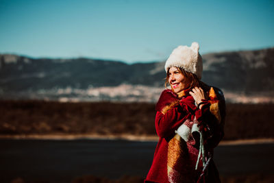 Portrait of woman standing on beach against sky