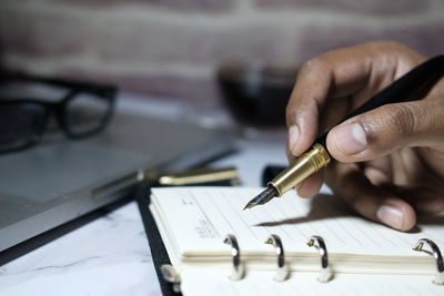 Close up of man hand writing on notepad