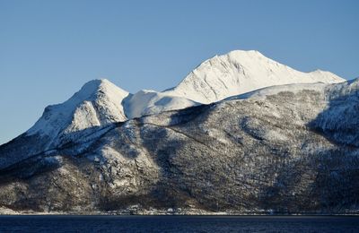 Scenic view of snowcapped mountains against clear blue sky