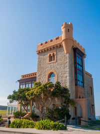 Low angle view of building against clear blue sky