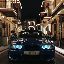 Cars on road by buildings in city at night