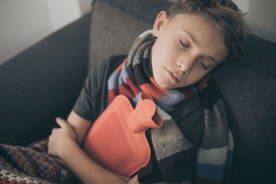 High angle view of boy lying on sofa at home