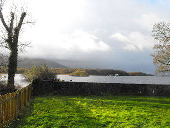 Scenic view of river against cloudy sky