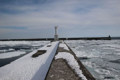 Frozen sea against sky during winter