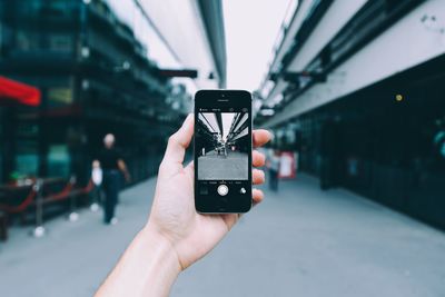 Cropped image of hand holding camera