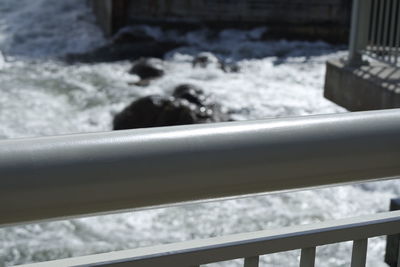 Close-up of railing by sea
