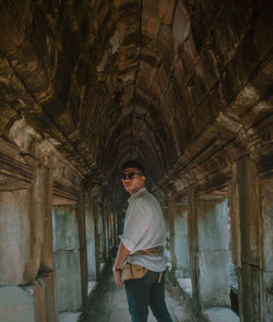 Portrait of young man standing against building