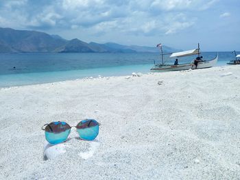 View of shoes on beach against sky