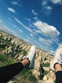 Low section of person on landscape against sky