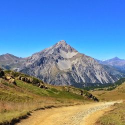 Scenic view of snowcapped mountains against clear blue sky