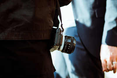 Midsection of man with camera