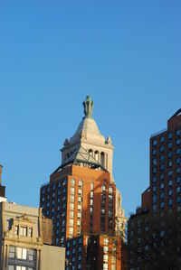 Low angle view of buildings against blue sky