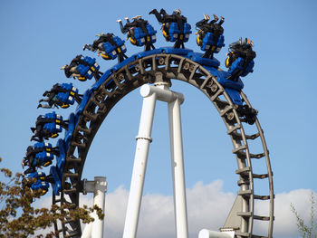 Low angle view of ferris wheel against blue sky